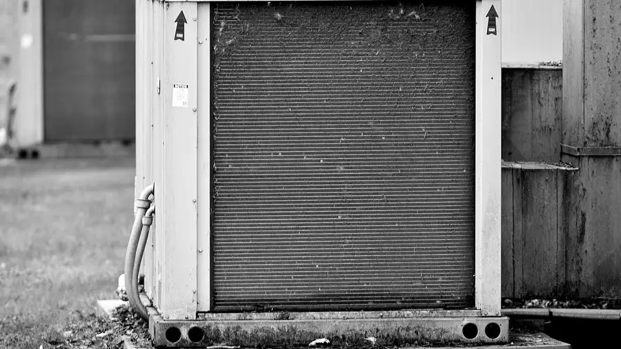 Black-and-white close-up of the metal coil face of an outdoor HVAC unit