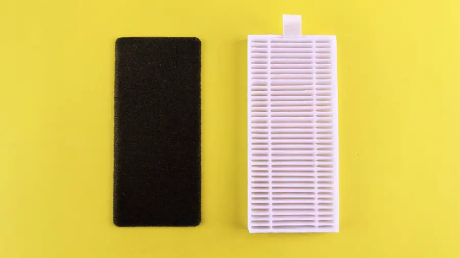 Pleated white air filter on a yellow surface