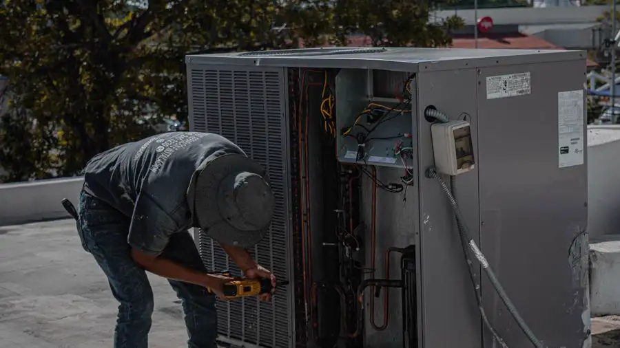 Technician working on an air conditioner on a rooftop