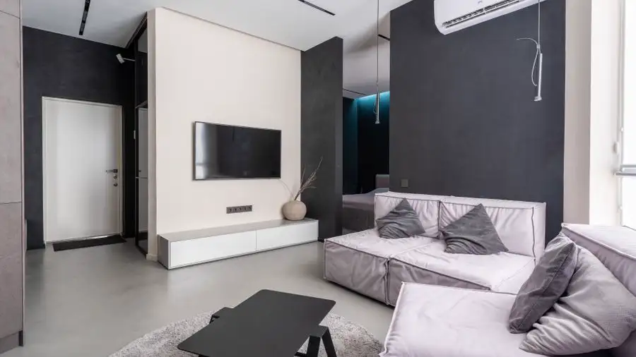 Living room with a wall-mounted mini-split air conditioner high on the wall