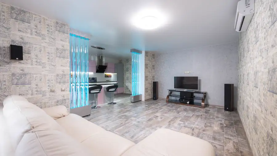 Bright living room with a white sofa and an air conditioner mounted high on the wall