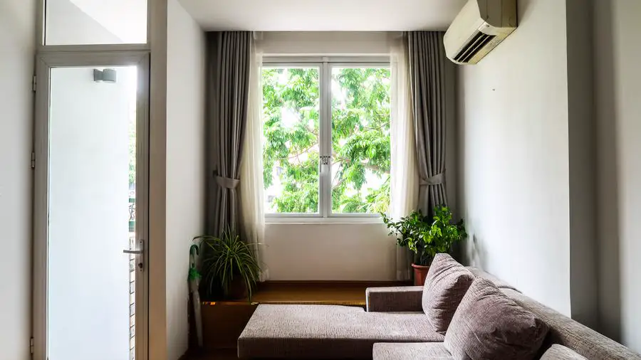 Living room with a wall-mounted air conditioner above the window