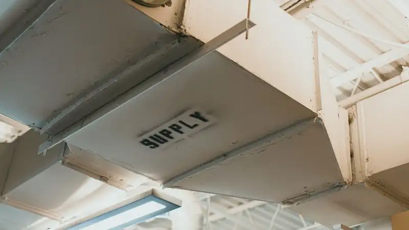 Close-up view of an air duct labeled 'SUPPLY' in an industrial setting