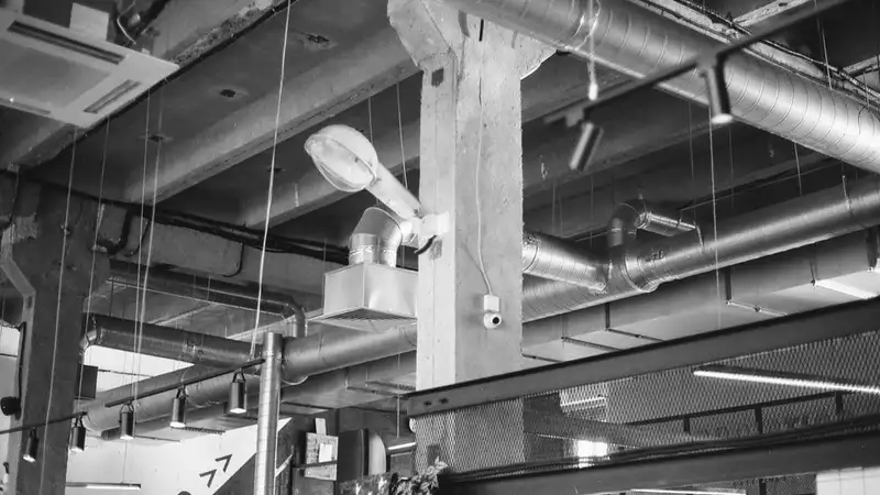 Black and white photo of industrial interior with exposed ducts and pipes in Saint Petersburg