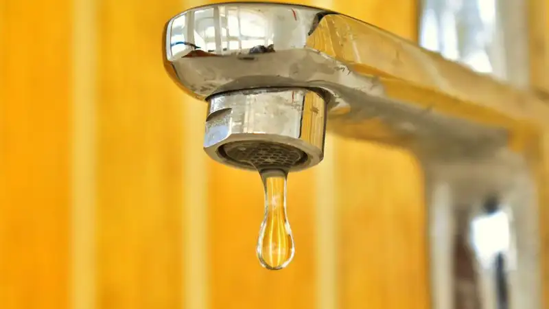 A drop of water about to fall from a faucet