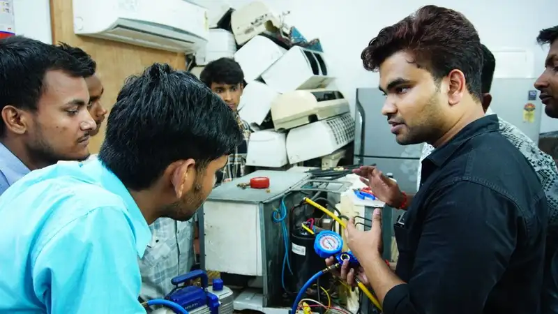 Participants learn AC repair during a hands-on session in Delhi, India