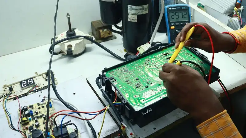 Technician working on AC PCB with tools and equipment, captured in New Delhi workshop
