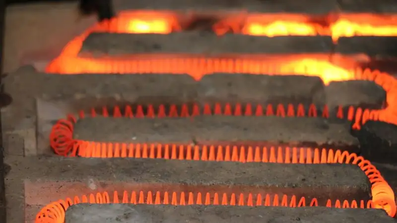 Detailed view of a glowing electric heating element with a coiled structure emitting heat