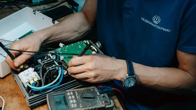 A technician methodically repairs a circuit board, showcasing expertise in electronics and technical skills