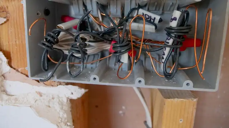 Detailed view of an open electrical switchboard with tangled wires and cables